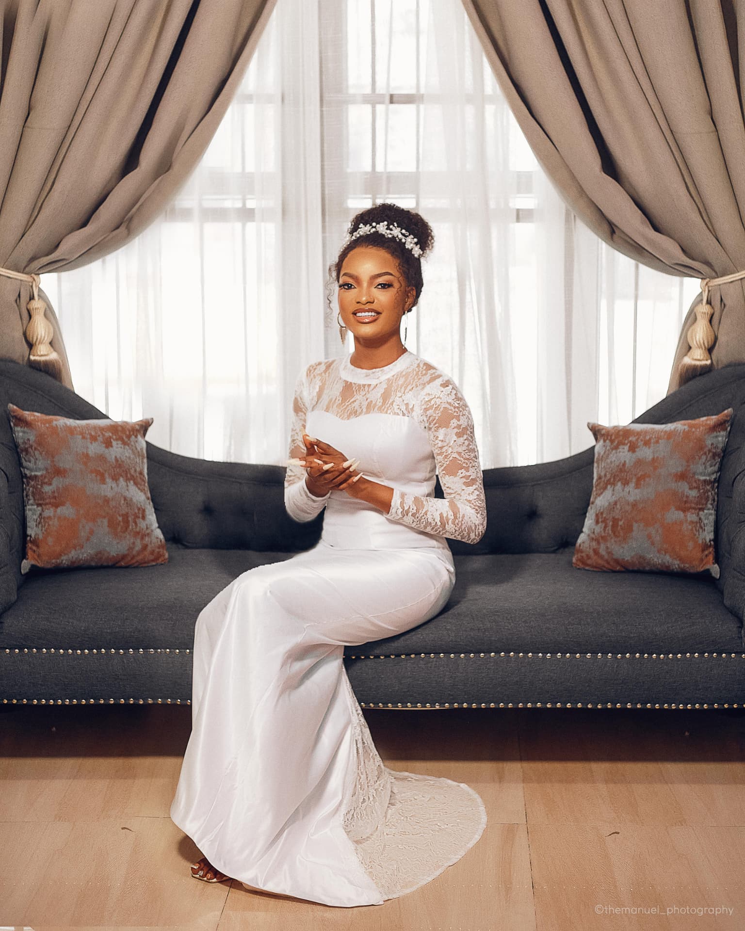 TF GLAM bridal makeup: a Lagos bride in white on a sofa